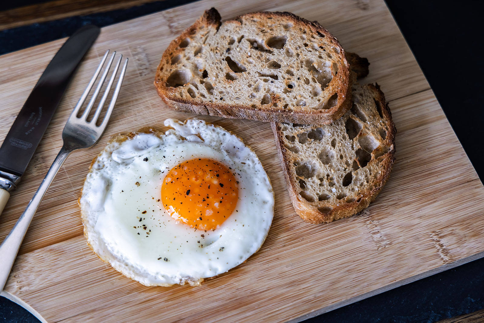 Fried egg next to toast.